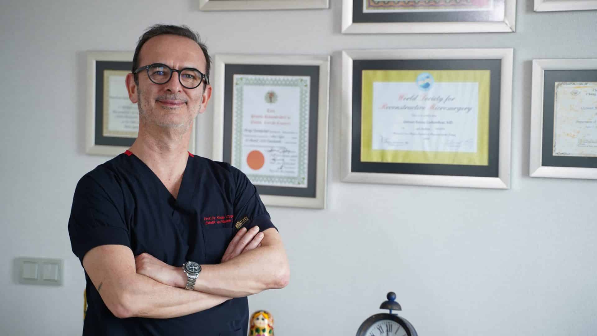 Prof. Dr. Koray Coşkunfırat klinik kıyafetiyle muayenehanesinde.